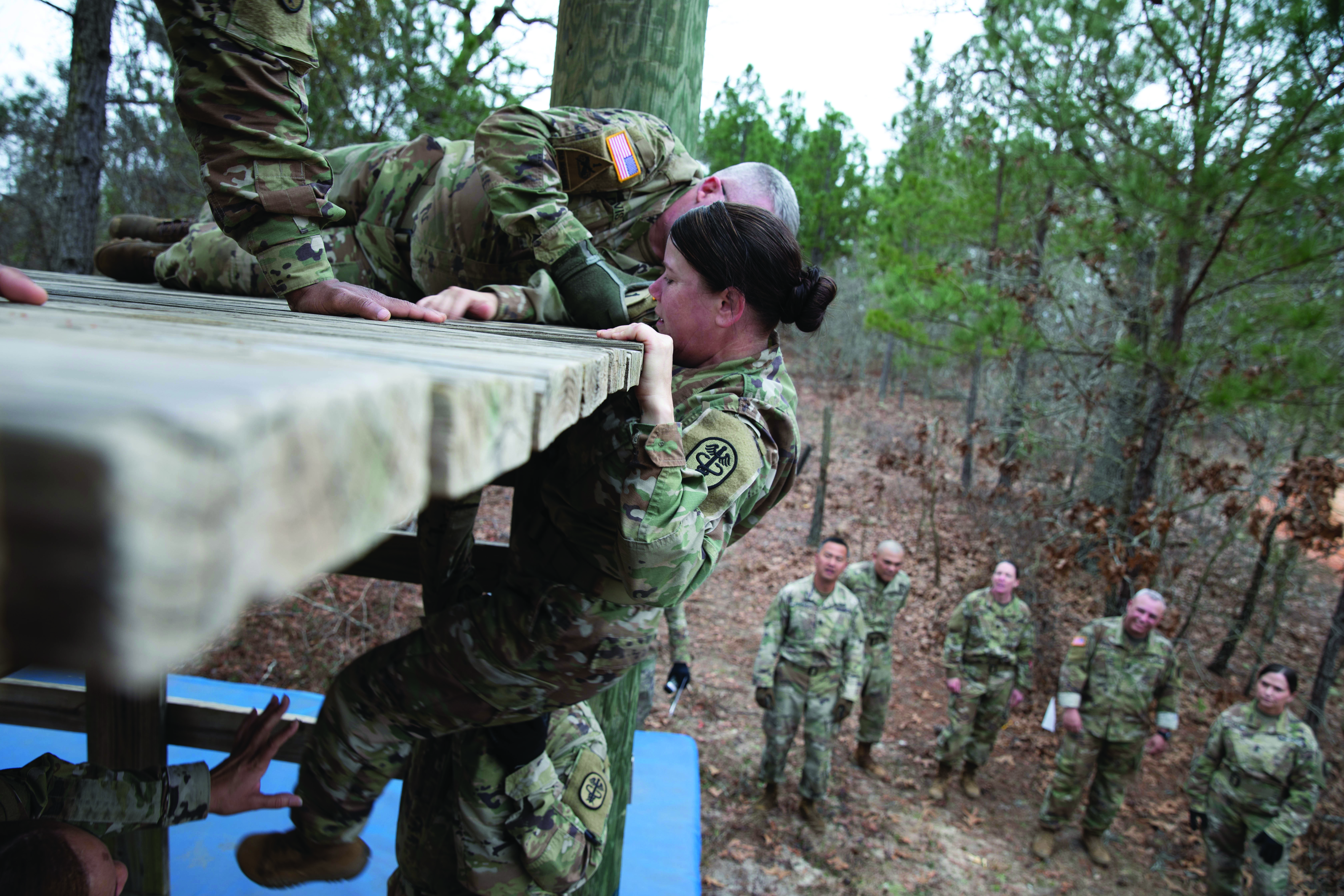 Command sergeants major work together to climb
        an open face tower at Fort Gordon, GA. (Credit: SPC
        Jordan Buck)